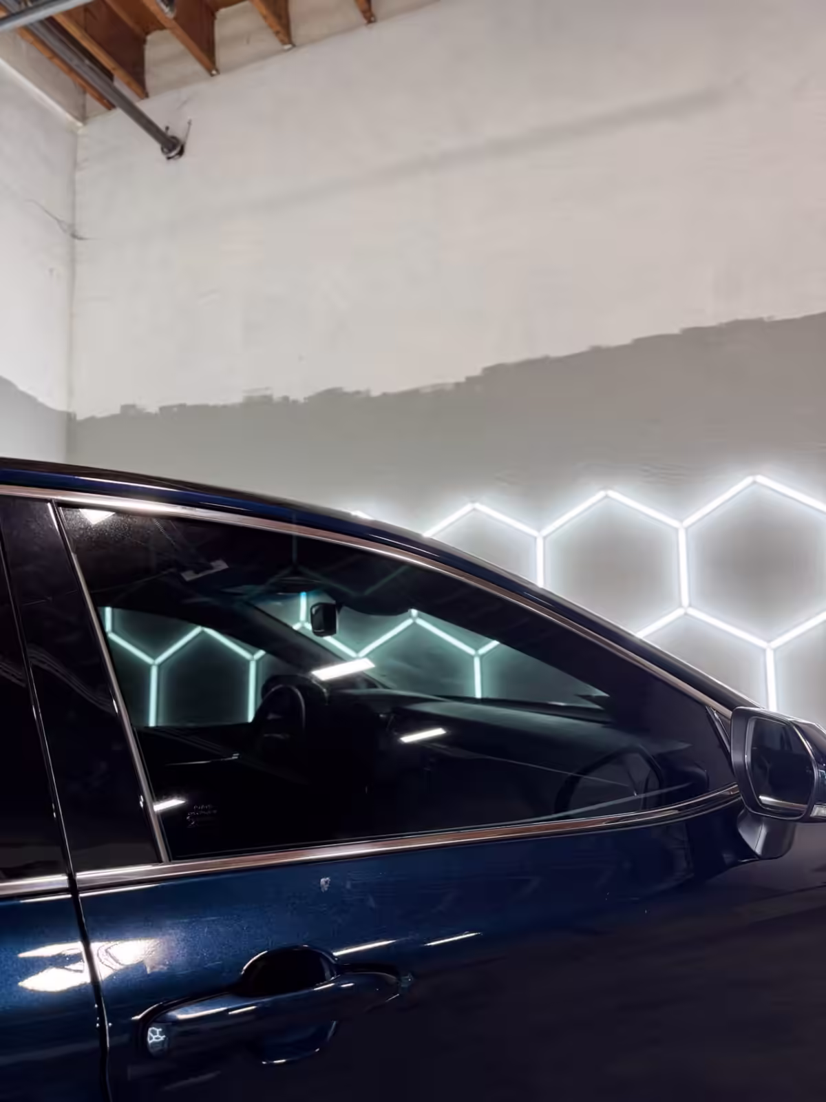 Close view of tinted side windows on a blue sedan