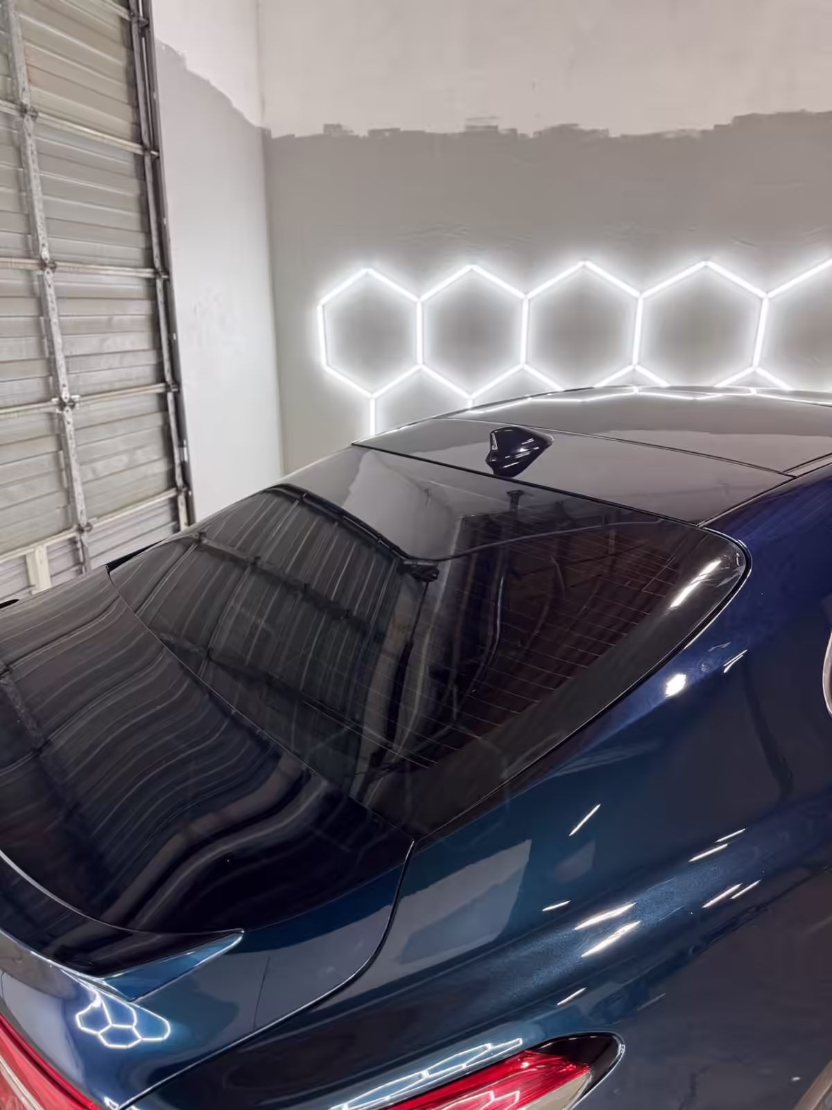 Fresh rear window tint on a blue sedan